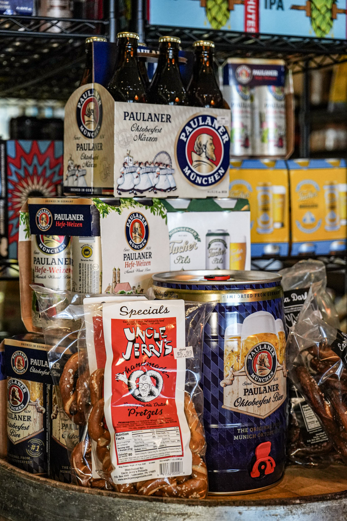 Local and regional craft beer cans and bottles displayed on a barrel at Chord Bread & Bottle